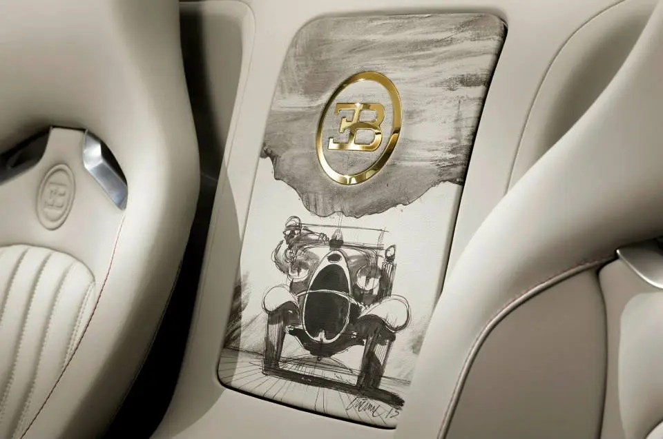 Gold can also be found inside the vehicle* itself, such as the EB logo on the cover of the rear storage compartment, which is also finished in beige leather and hand-painted with a motif showing the historic vehicle.