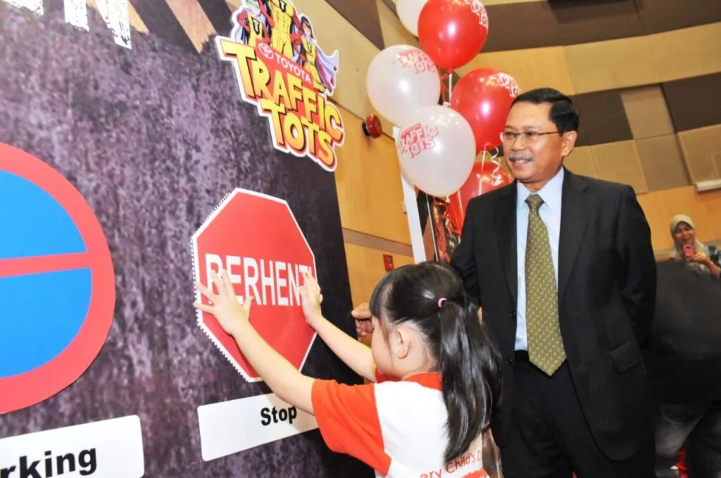 Datuk Ismet Suki assisting a student with the road sign during the_ programme launch.