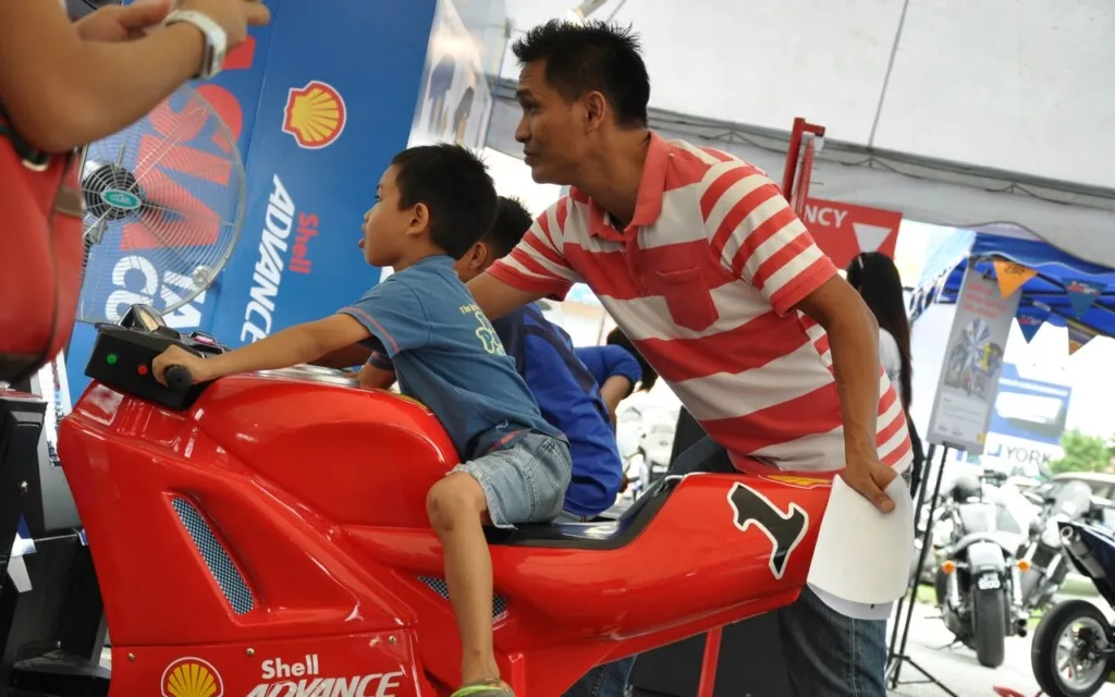 Future Shell Advance Asia Talent Cup rider...A father encouraging his son on the bike simulator at the Shell Advance On Wheels Roadshow
