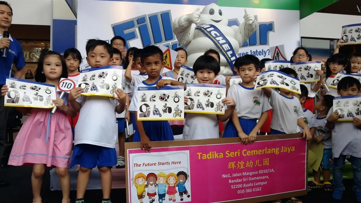 Children from Seri Cemerlang Jaya Kindergarten receiving Michelin Man stickers and a school bag as a reward for their effort in completing the activities