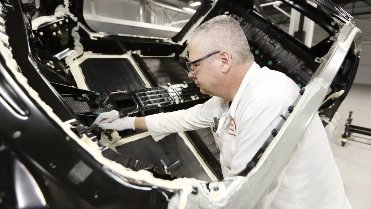 Ernie Jamison applies sealer to an NSX body. The use of two rotisseries in the body sealing application process allows the body to be elevated and rotated 360 degrees ñ providing for more precise application of sealer and improved ergonomics for technicians.
