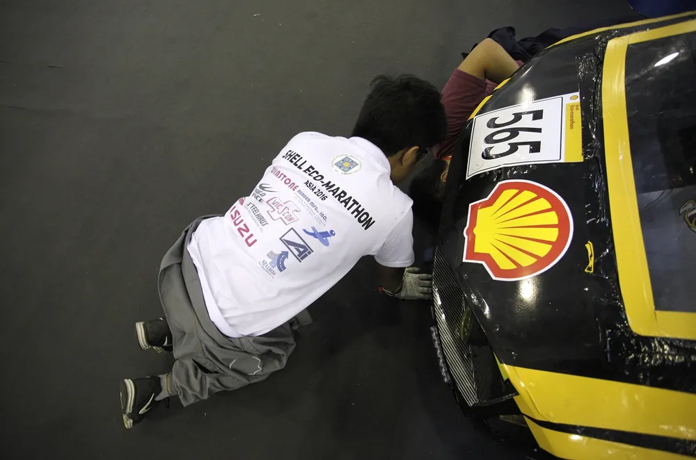 Team members work on the T400E, #565, a ethanol UrbanConcept vehicle from team UST Eco-Tigers II at the University of Santo Tomas (UST) in Manila, Philippines,  during day two of the Shell Eco-marathon Asia in Manila, Philippines, Friday, March 4, 2016. (Geloy Concepcion via AP Images)