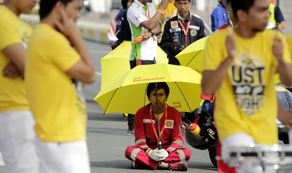 A crew member from the Nanyang Venture IX, #305, a battery electric prototype vehicle from team Nanyang E Drive at the Nanyang Technological University in Singapore, Singapore, sits on the track at the starting line during day two of the Shell Eco-marathon Asia in Manila, Philippines, Friday, March 4, 2016. (Geloy Concepcion via AP Images)