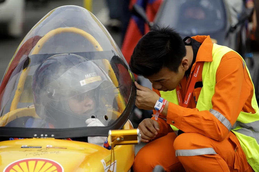 Team members of the EcoTraveller, #303, a battery electric prototype vehicle from team EcoTraveller at the Institute of Technical Education (ITE) in Singapore, readies their car at the starting line during day two of the Shell Eco-marathon Asia in Manila, Philippines, Friday, March 4, 2016. (Geloy Concepcion via AP Images)