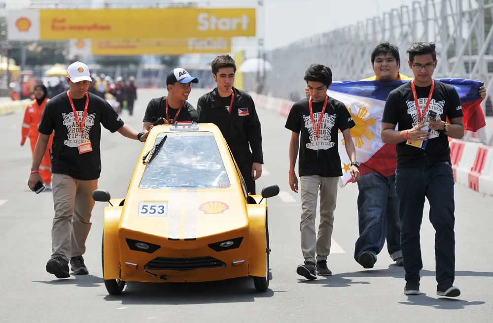 The TiP PiP GT,  #553, a CNG (Compressed Natural Gas) UrbanConcept vehicle from team TIP GTE Efficacy at the Technological Institute of the Philippines, Quezon City in Quezon City, Philippines, pushes their car into position for a group portrait during day one of the Shell Eco-marathon Asia, in Manila, Philippines, Thursday, March 3, 2016. (Jinggo Montenejo/AP Images for Shell)
