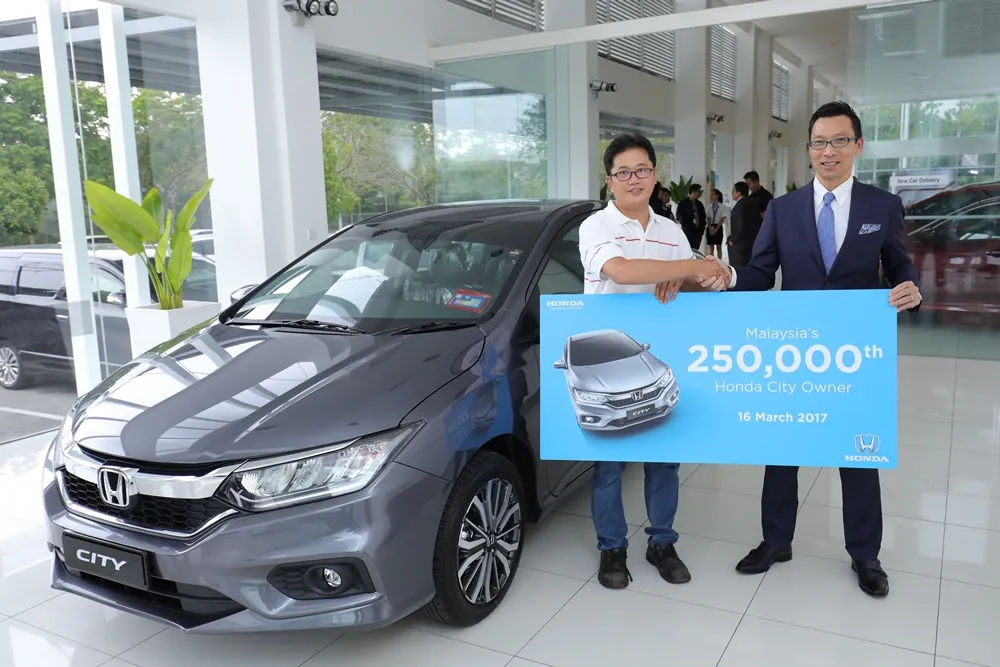 01 Honda Malaysia MD and CEO Mr Katsuto Hayashi congratulating Mr Tan Kian Hui - the owner of the 250,000th City
